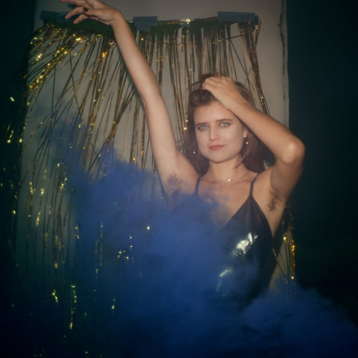 model posing with hands in the air and gold fringe across her face.