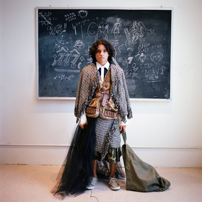 model in layers in front of a chalk board.