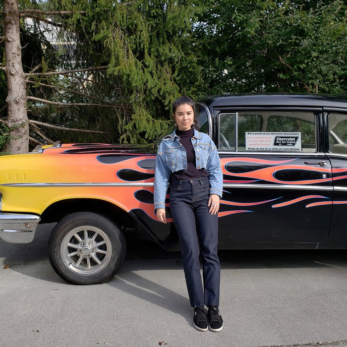 person leaning at black old car with flames detail. 