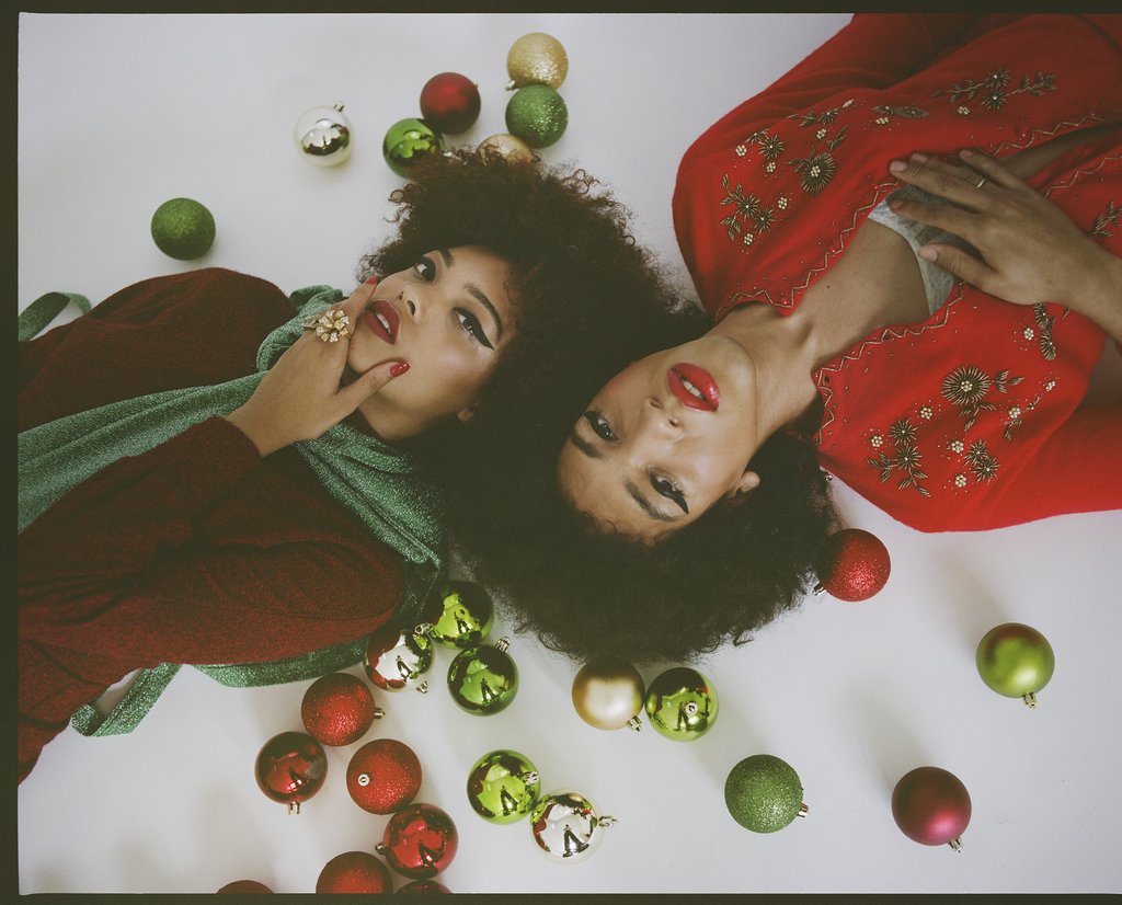 glam holiday looks on two models laying down.