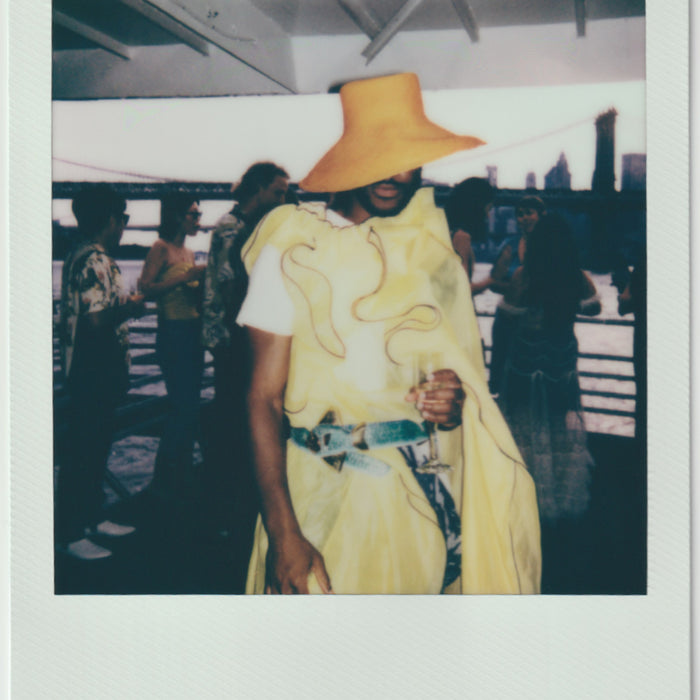 employee wearing all yellow outfit, posing - polaroid style.