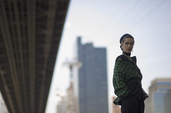 model featured in front of bridge.