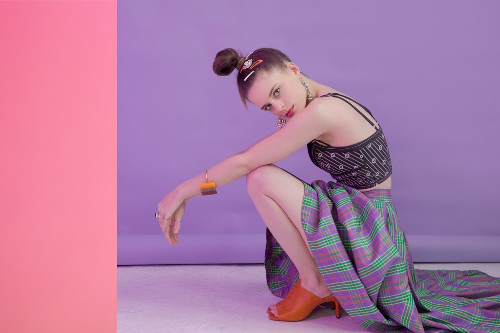 model posing in a crouching position on the floor.