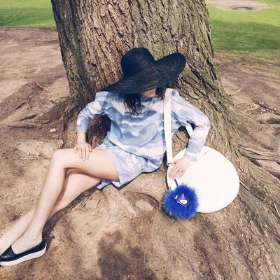 model laying on tree trunks.