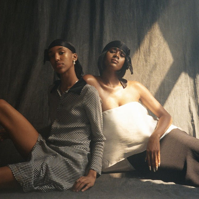 two models seated posing. 