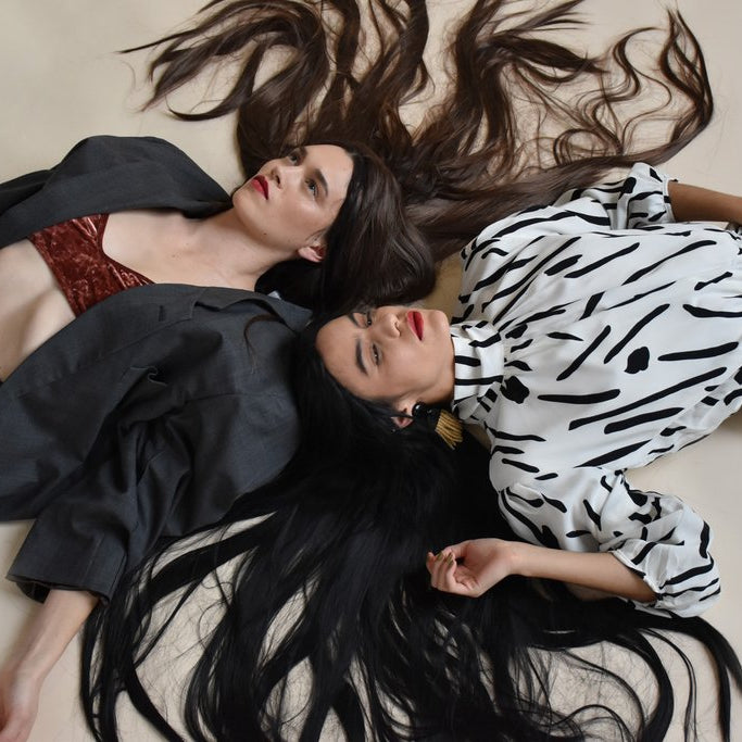 two models laying down with their long hair everywhere.