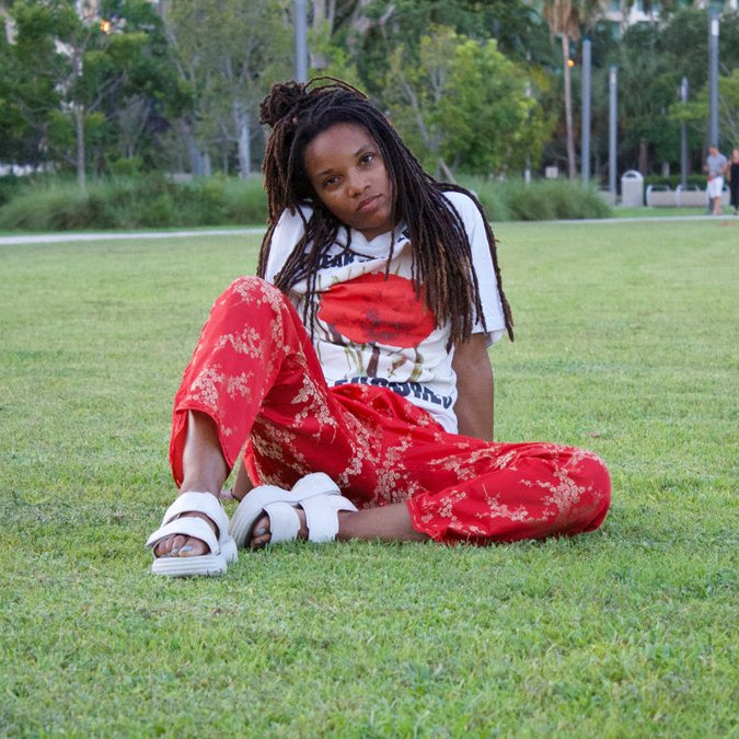 person with red pants sitting at grass. 