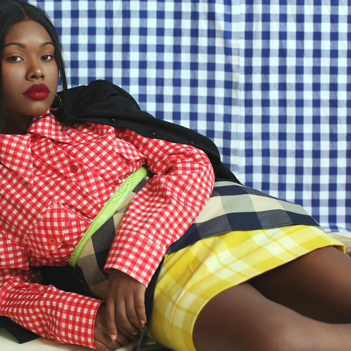 model posing on ground in checkered themed shoot. 