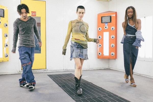 three models walking in car painting room.