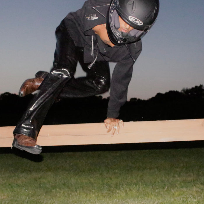 andre molina in full look jumping over a fence.