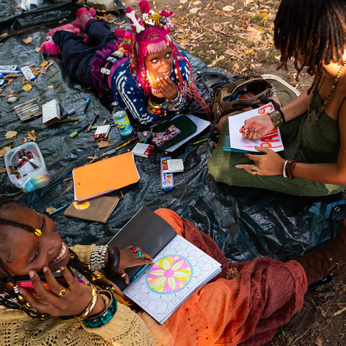 fetsival attendees sitting on blanket drawing at pow fest