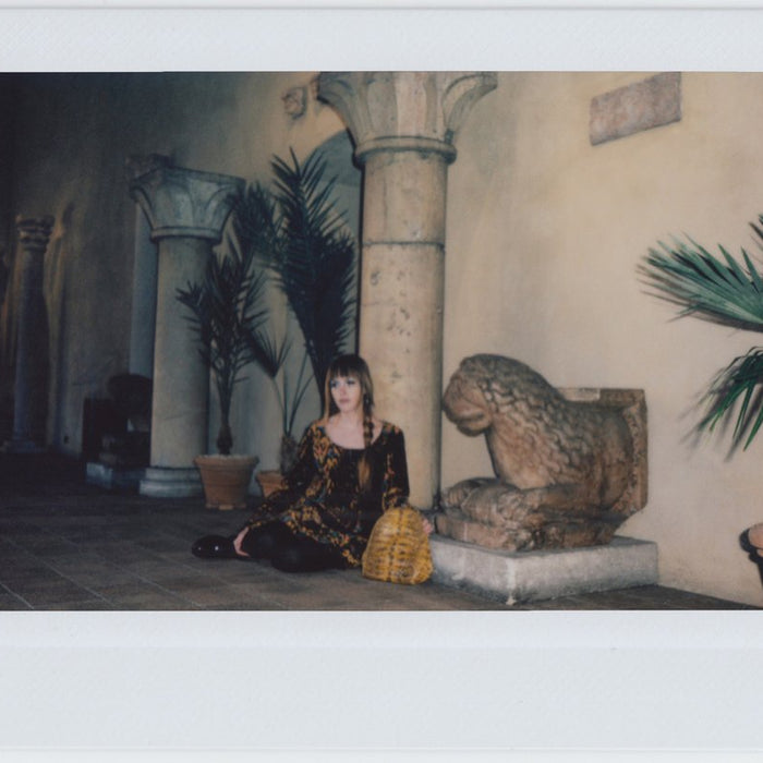 ana seated by pillar and statue.