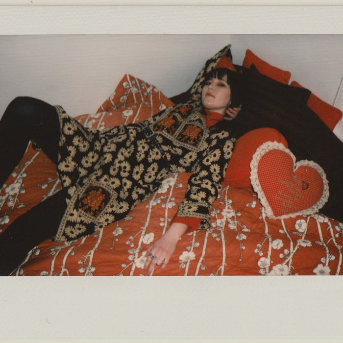 ashley posing on bed spread in vintage piece. 