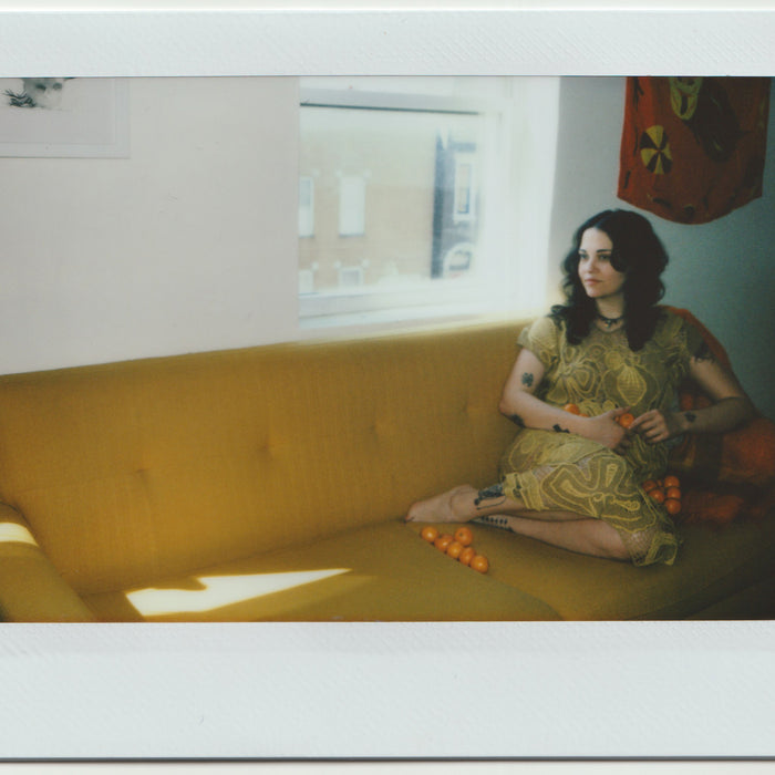 chelsea seated on couch below window.