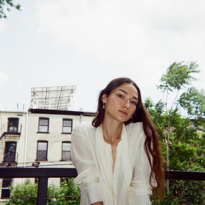 bruna seated on balcony posing.