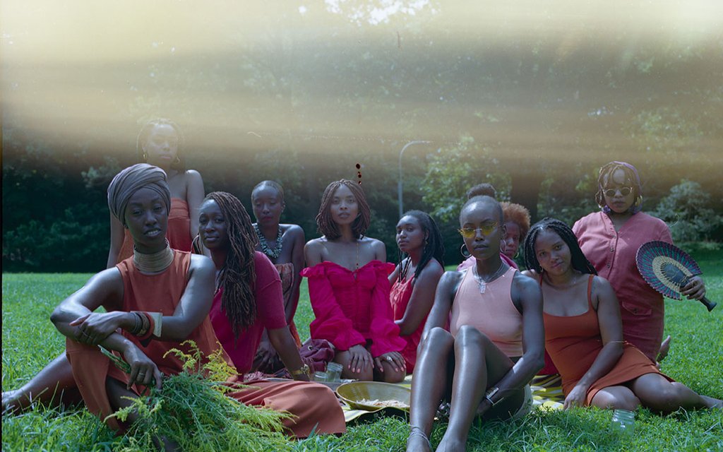 mel chanté and friends seated on a lawn, still from music video.