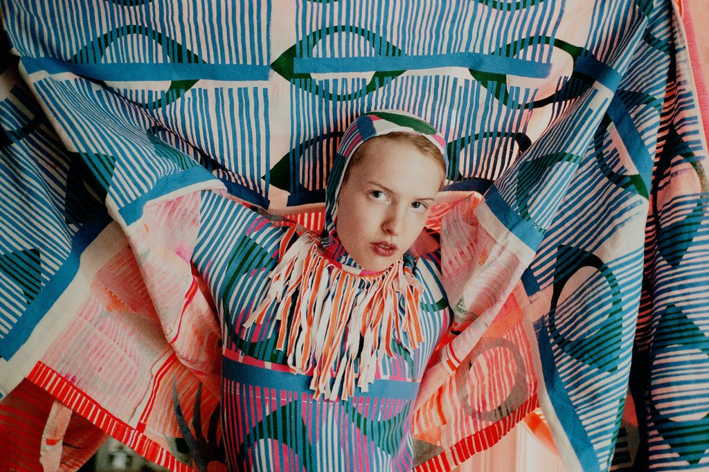 conceptual dress held by model over their head.