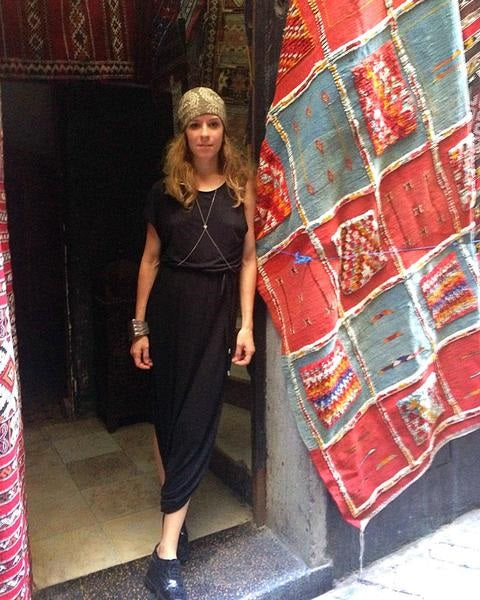 julia posing next to carpet at market.