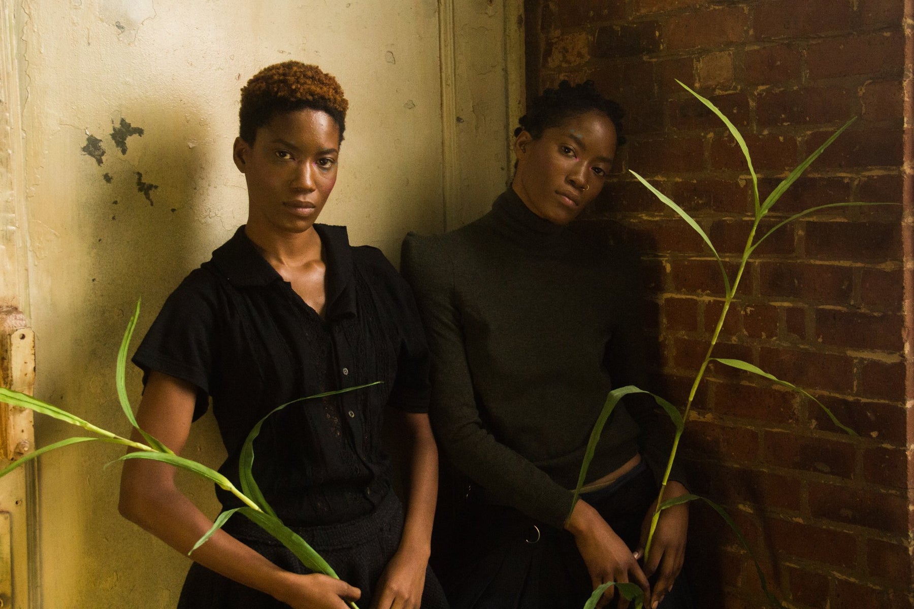 portrait of twin models posing in corner. 