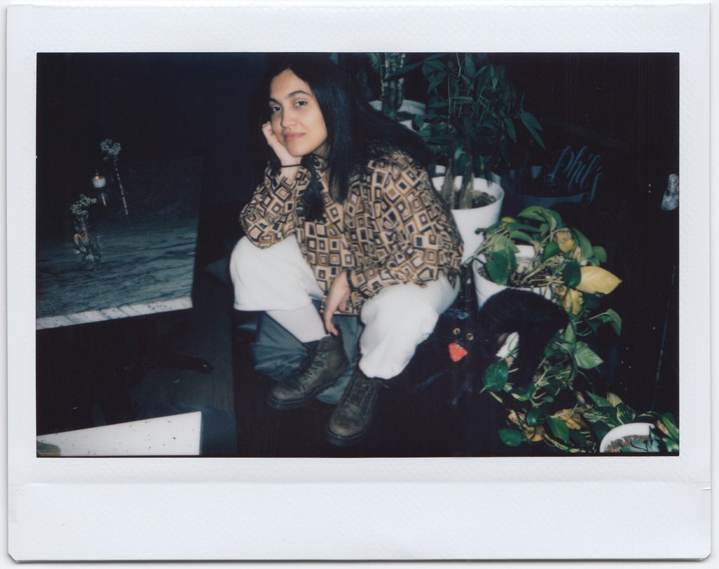 ana sitting by potted plants.