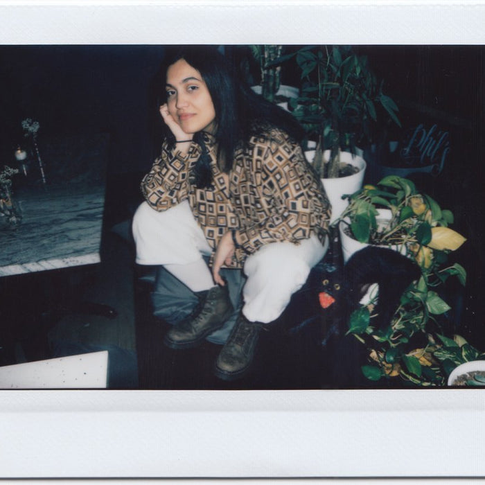 ana sitting by potted plants.