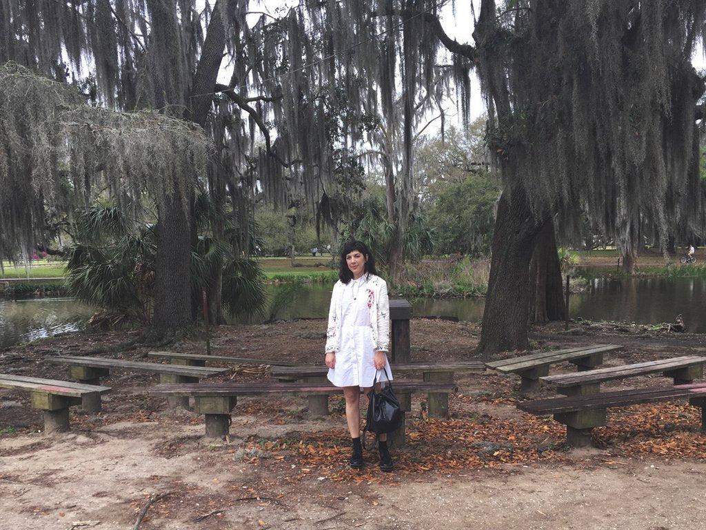 a person standing next to a bench in a park.