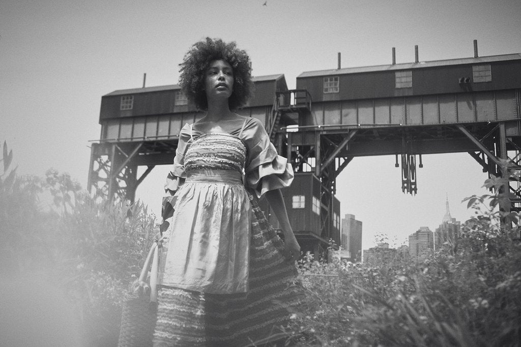 model posing with flowers and industrial structure.