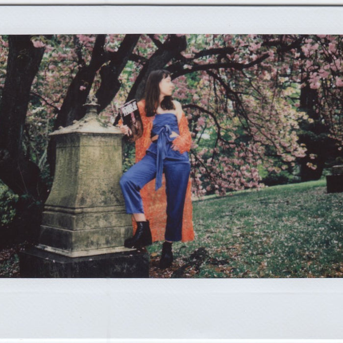 susy in jumpsuit and trench coat in the park.