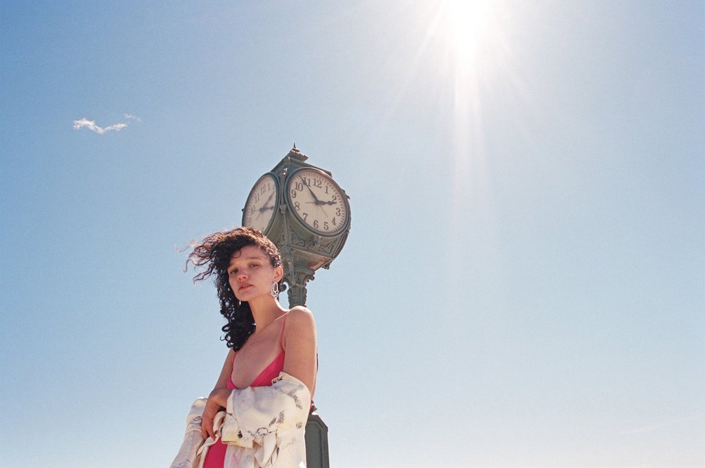 model in front of clock.