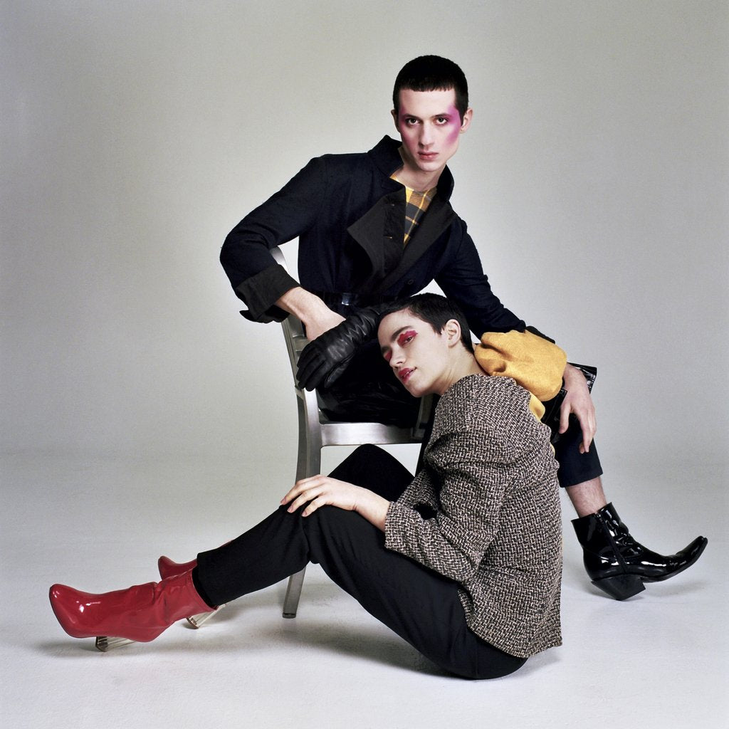 models in conceptual looks posing in seated positions.