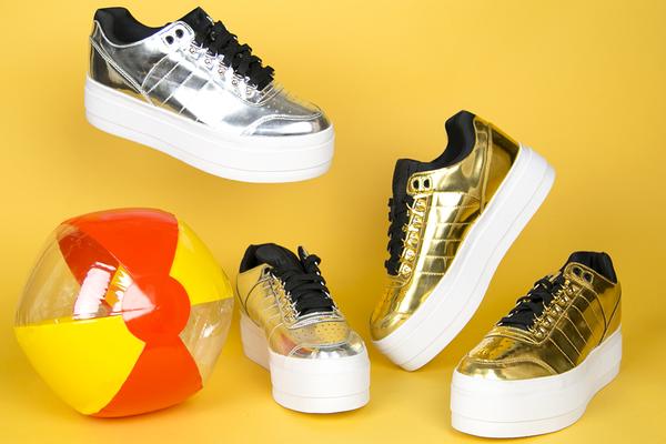 still life featuring beach ball and metallic platform sneakers. 