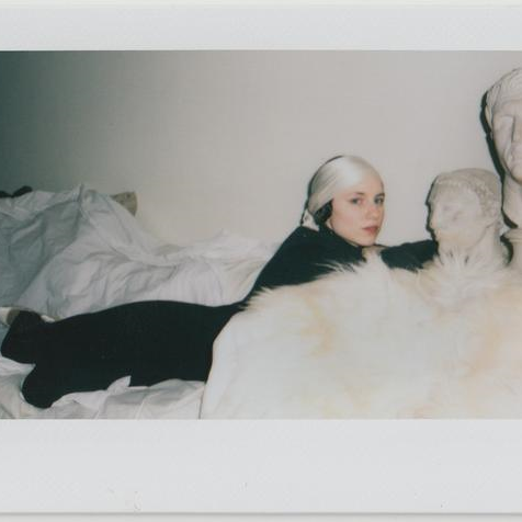 sarah lounging on couch with two busts.