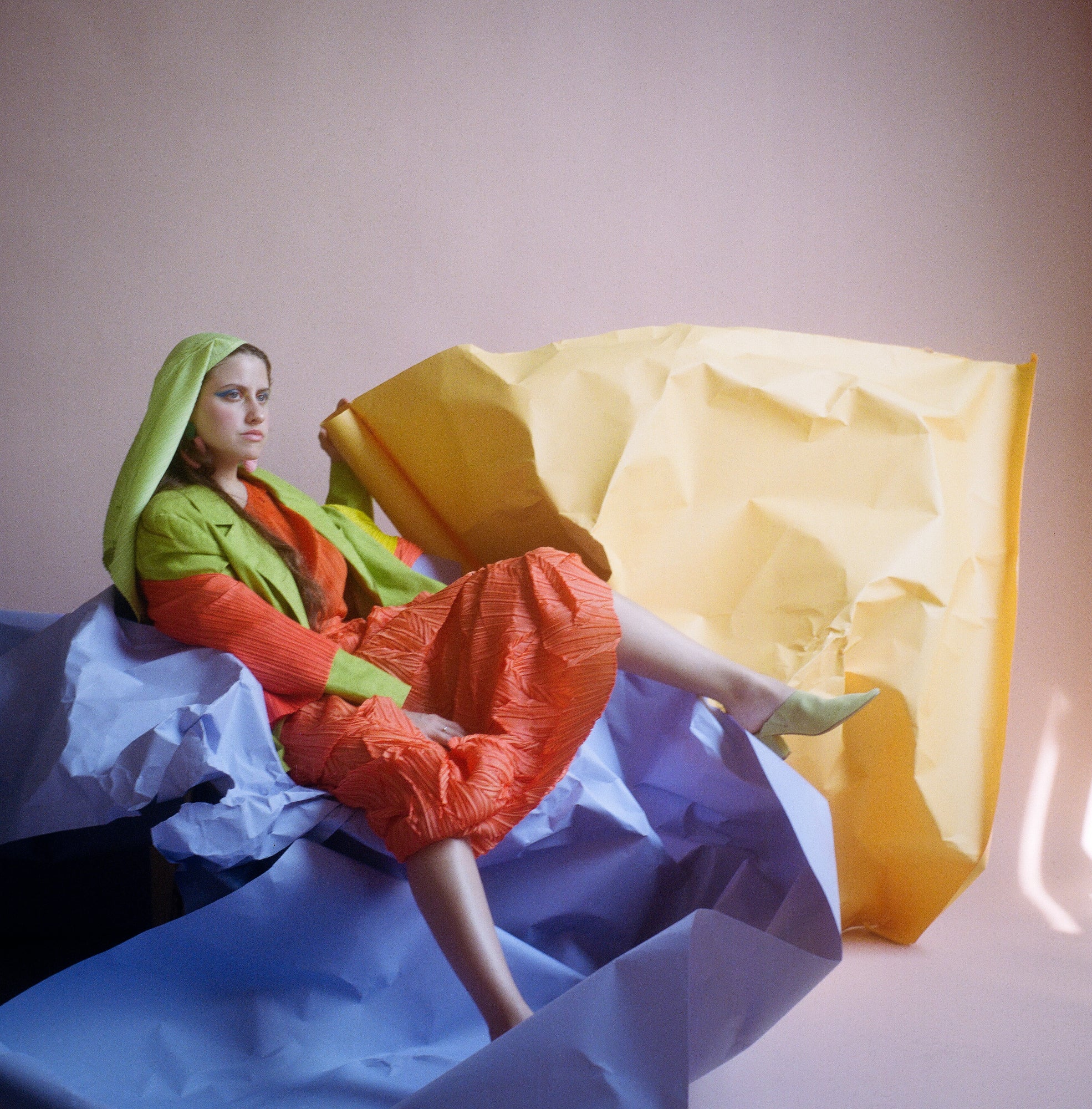 woman sitting on large pieces of crumpled paper