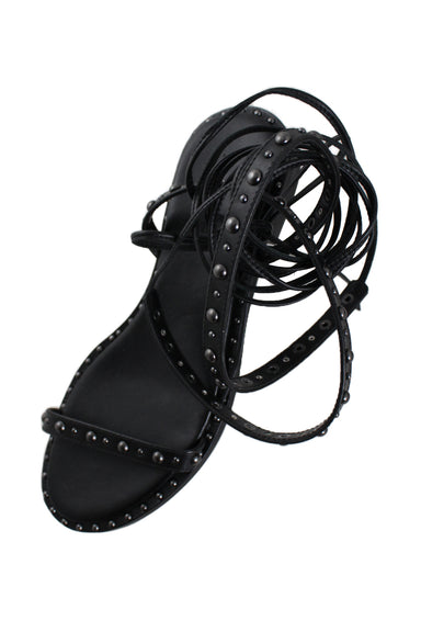 elevated three-quarter angle rebecca minkoff black strappy leather sandals featuring graphite toned stud embellishment and lace-up straps.