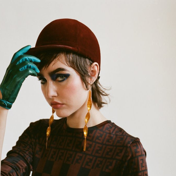 portrait of a model in a riding hat and glove. 