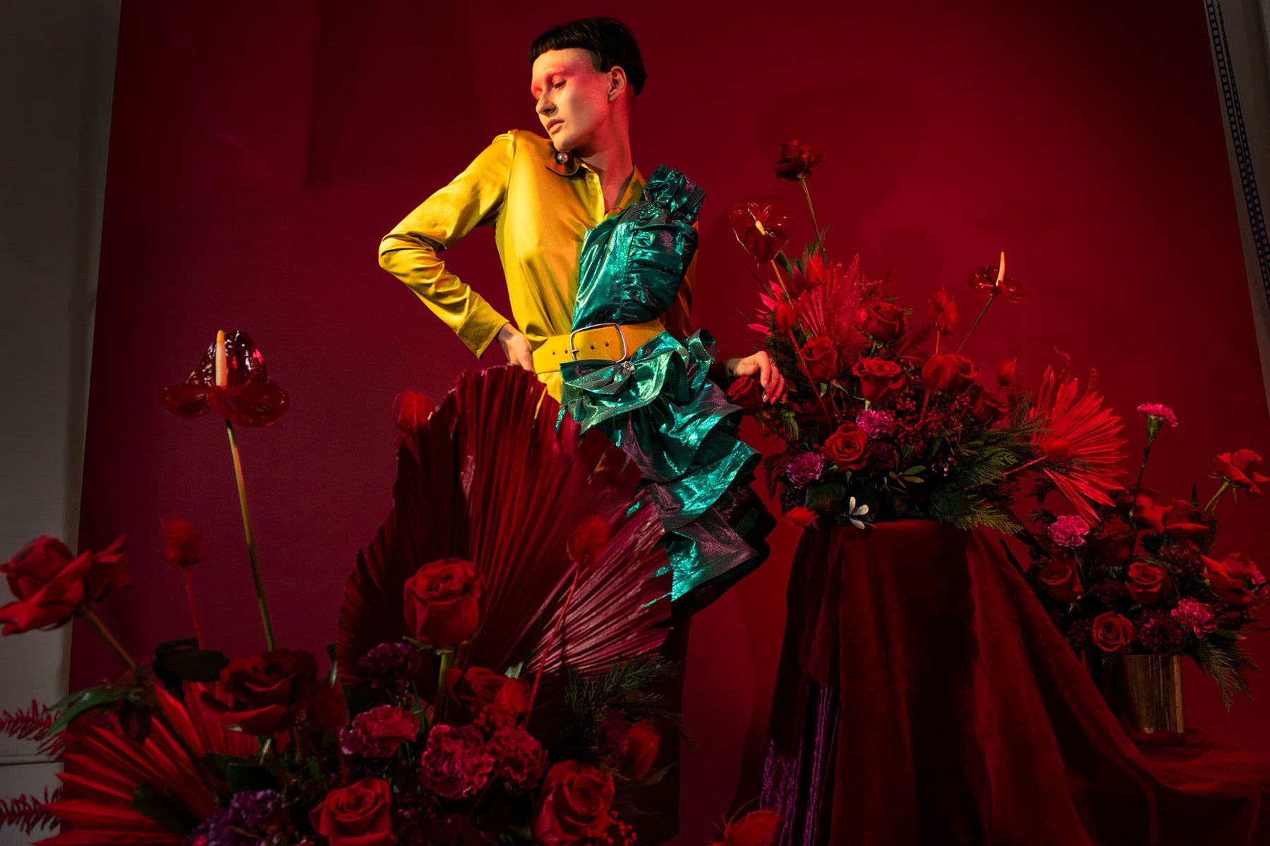 model seated with floral displays.