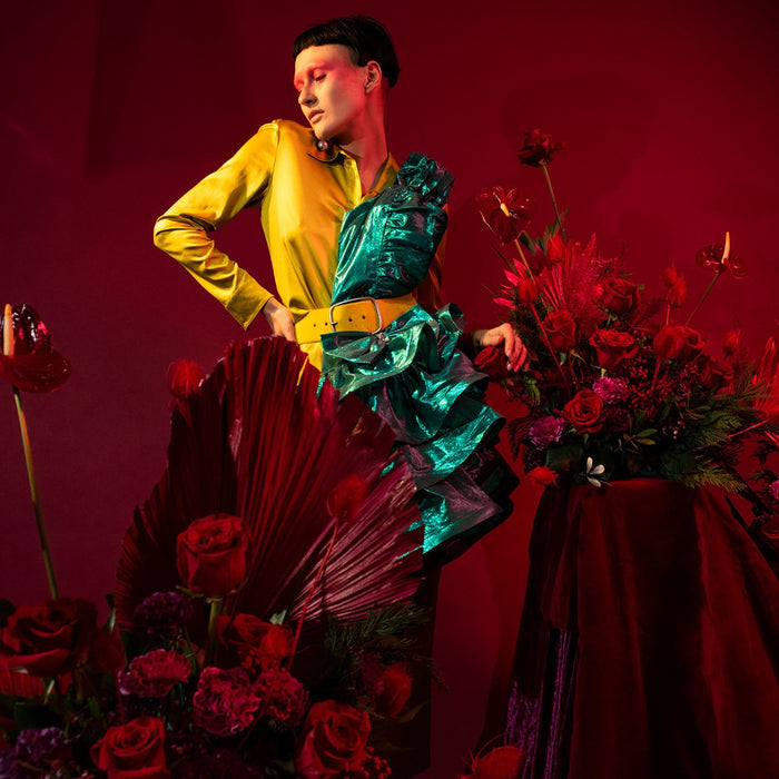 model seated with floral displays.