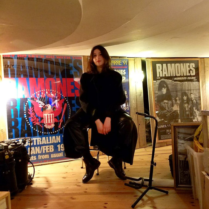 person sitting in the chair at ramones museum. 