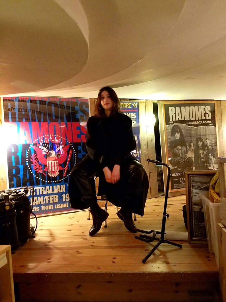 person sitting in the chair at ramones museum. 