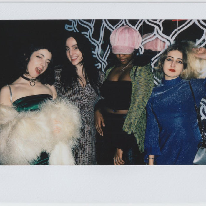 quartet posing in stylish outfits. 