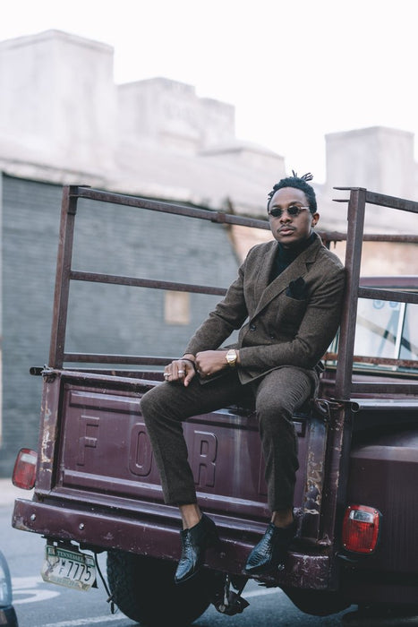 osi sitting on tailgate of vintage ford truck in vintage two-piece suit.