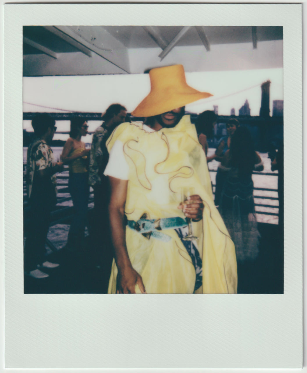 employee wearing all yellow outfit, posing - polaroid style. 