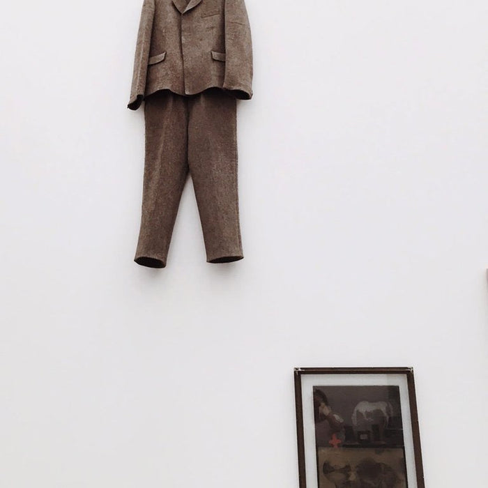 a suit hangs on a wall in a room.