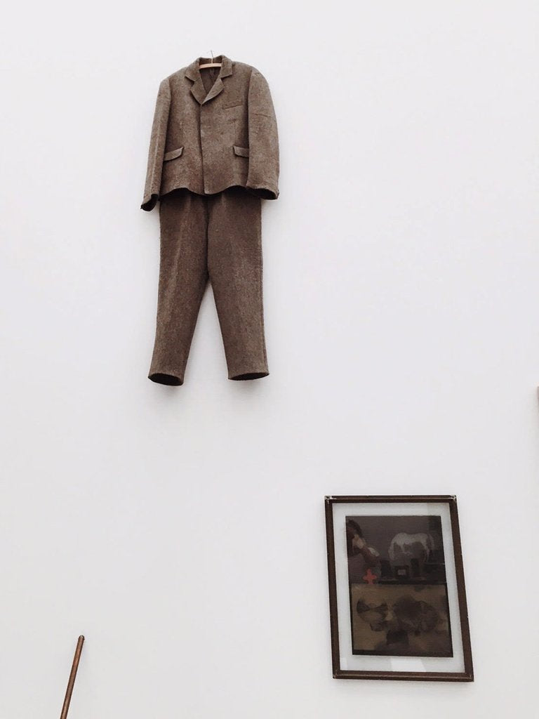 a suit hangs on a wall in a room.