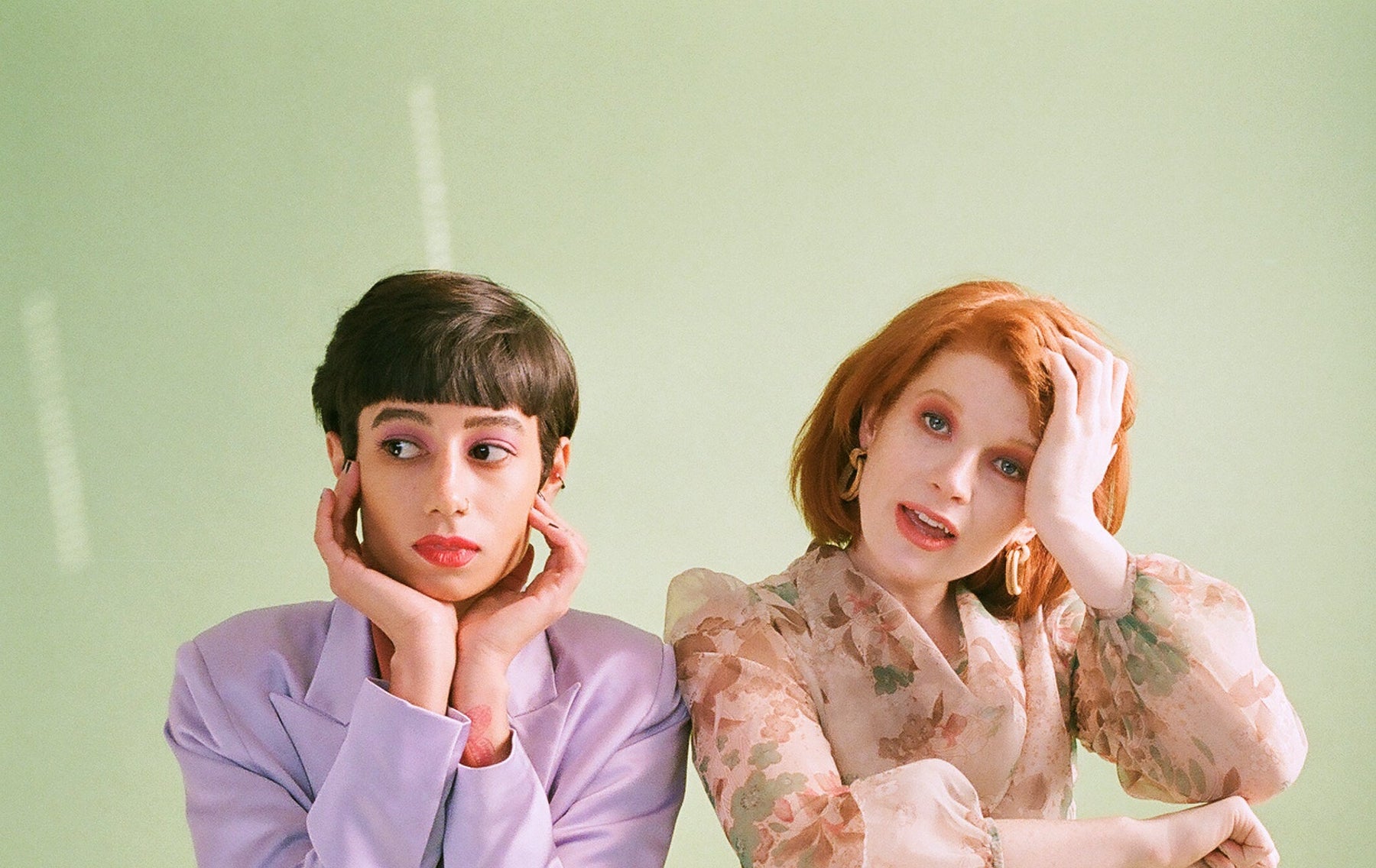 two models seated and captured in a portrait. 