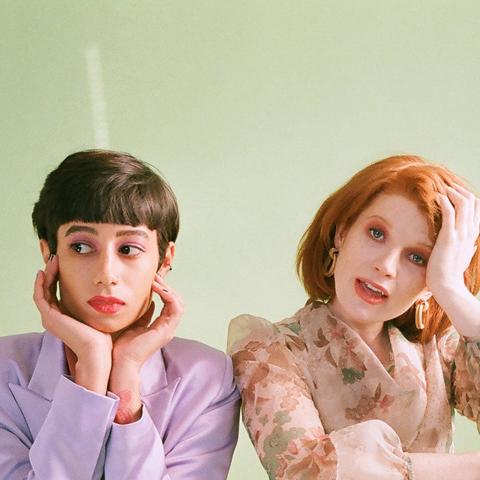 two models seated and captured in a portrait. 