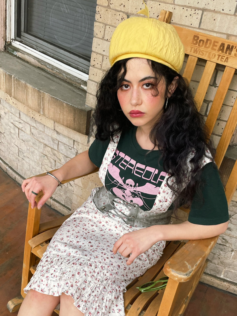 allyson sitting in chair wearing t-shirt with 'stereolab' text.