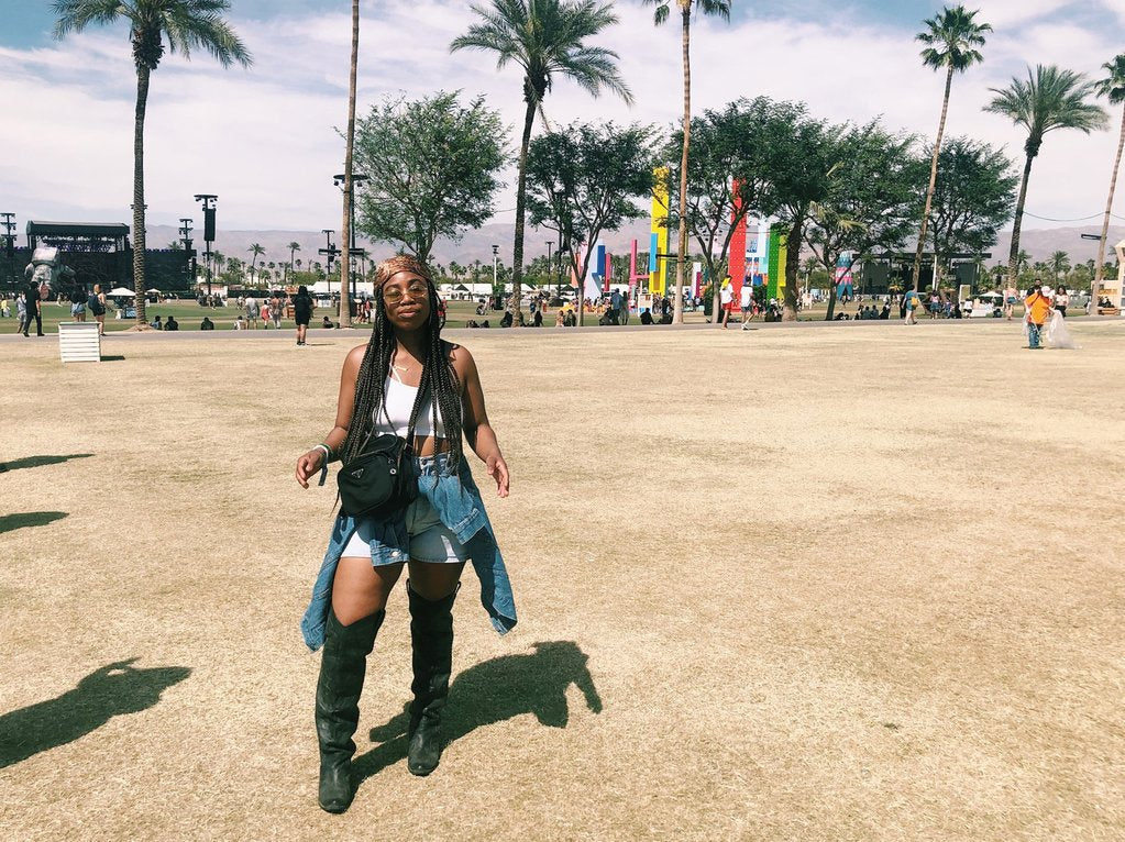 person with high boots posing, palm trees in the background. 
