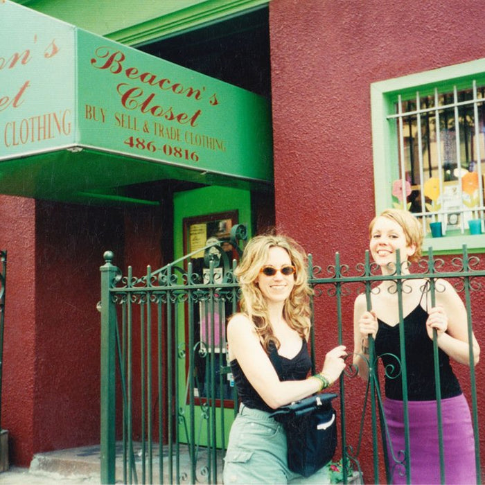 carrie and friend in front of original store front, awning reads beacon's closet buy sell trade 486-0816.
