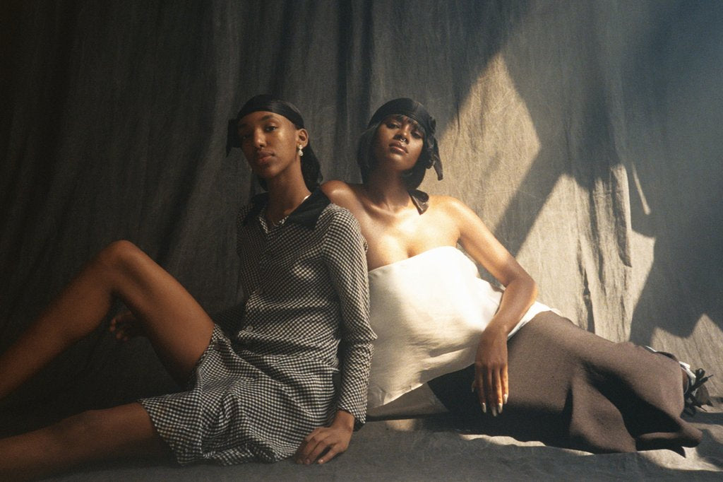 two models seated posing. 